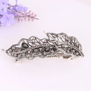 Detail view of a vintage crystal ponytail clip with antique silver leaf design
