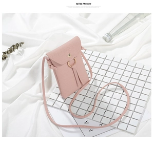 Dettaglio di una mini borsa a tracolla rosa con anello in metallo e trama martellata