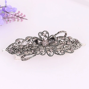Vintage silver alloy hair clip with intricate hollow patterns and purple crystals