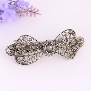 Close-up of vintage alloy ponytail hair clip with smoky grey crystals and hollow pattern