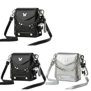 Detail of crocodile embossed crossbody bag with metal butterfly clasp and chain