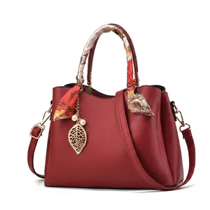 Detailed view of women's lychee grain handbag in five colors with silk scarf handle detail