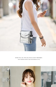 Silver shoulder bag with metallic butterfly logo, chunky chain, and cute bear charm detail