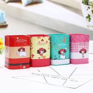 Four colorful cartoon tinplate storage boxes in red yellow green and pink on a sunny window