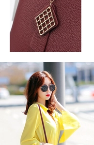 Detail of lychee textured leather and gold clasp on a burgundy shoulder bag for women