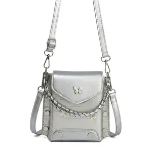 Close-up of silver crossbody bag featuring metal butterfly detail and punk chain decor