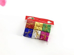 Detail of six assorted metallic laser foam Christmas gift box ornaments in clear packaging