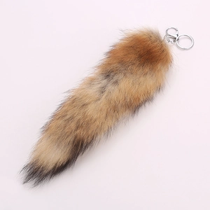 Detailed macro view of a large fluffy fox tail keychain with silver metal lobster clasp