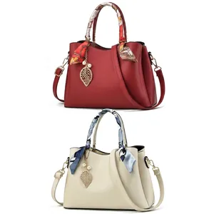 Détail du sac à main en cuir avec poignées en foulard de soie et breloques en perles
