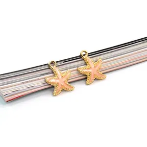 Dettaglio dei ciondoli a stella marina con bordi dorati e smalto rosa per gioielli fai da te