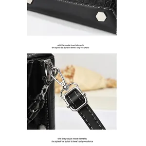 Detail of crocodile embossed black leather bag with silver rivets and metal swivel hooks