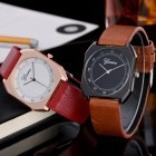 Close-up of square quartz watches with red and brown leather straps on a desk