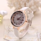 Detail of rose gold case and white PU leather strap with Roman numeral dial on beige paper