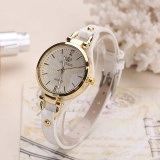 Macro detail of white faux leather strap with gold buckle on quartz fashion watch