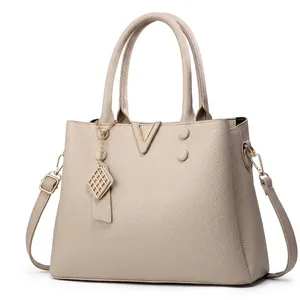 Detail showing various colors of pebble grain leather handbags with golden V-logo and charms