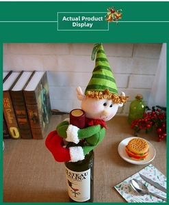 Close-up of Christmas elf wine bottle cover with green hat and red plush details