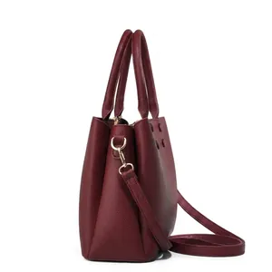 Detailed side view of wine red lychee grain leather tote bag with gold metal hooks