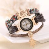 Detail of vintage cloisonné watch with gold leaf pendant and ethnic pattern woven band