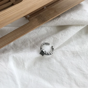 Macro shot of square black agate stone on silver braided vintage open band ring