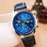 Detail of blue quartz watch dial with chronograph design and navy leather strap