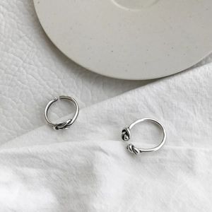Close-up of S925 sterling silver knotted rings with vintage finish on white leather