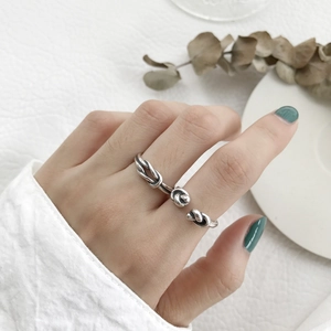Detailed shot of an S925 sterling silver knotted open ring on a finger