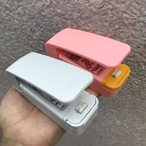 Mini portable heat sealer being held by hand showing compact size and ergonomic design