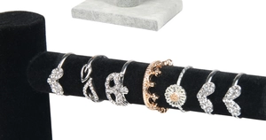 Detailed close-up of fashion ring set with heart and crown designs on velvet T-stand