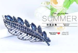 Detailed view of vintage alloy leaf hair clip with deep blue marquise-cut crystals