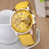 Detail of quartz watch with yellow leather strap and Roman numerals on golden dial