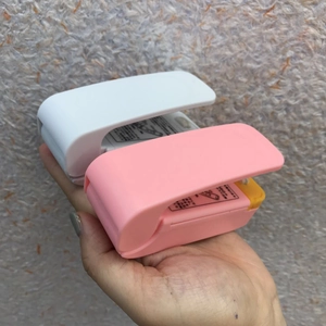Close-up of portable heat sealer showing the heating element and safety label