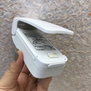 Detail view of mini bag sealer with safety guard and white plastic casing
