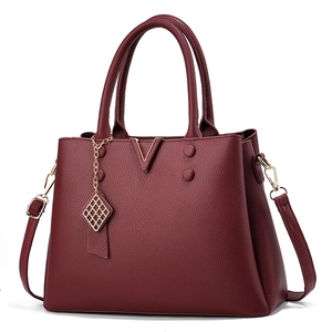 Elegant wine red lychee grain leather tote bag with V-shaped hardware and shoulder strap