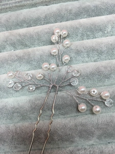 Detail of silver bridal hair pin with crystal beads and white faux pearls on branch
