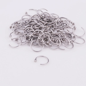 Close-up of silver C-shaped 316L stainless steel nose rings on a white background