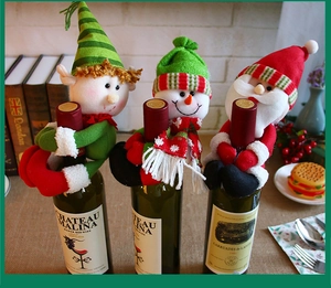 Detail of Christmas wine bottle covers featuring plush Santa, snowman, and elf dolls