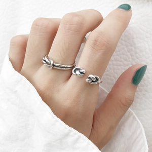 Detailed close-up of S925 sterling silver knotted open rings on model's hand