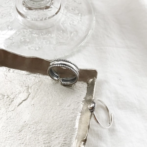 Detailed shot of two S925 sterling silver geometric open rings on a metal tray