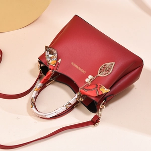 Elegant dark red crossbody handbag with silk scarf handle and golden leaf pendant