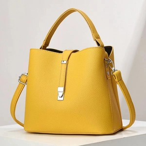 Détail du sac seau en cuir grainé jaune avec boucle argentée et bandoulière réglable