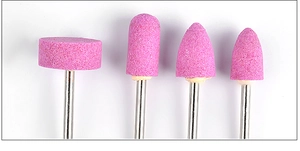 Detail view of four pink quartz nail drill bits in cylindrical and bullet shapes