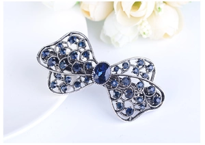 Detail of vintage bow hair clip with navy blue rhinestones and silver alloy finish