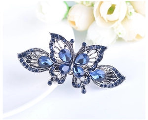 Close-up of alloy butterfly hair clip with blue rhinestones and filigree design