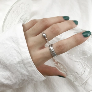 Detail of stacked S925 sterling silver rings with geometric beads and vintage textures