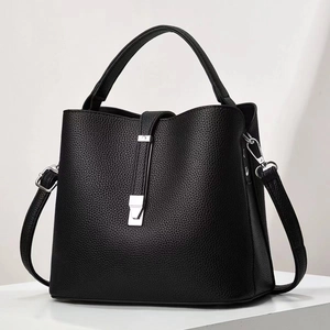 Détail d'un sac à main noir en cuir grainé avec boucles métalliques argentées