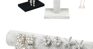 Macro detail of velvet earring display stand with rhinestone and pearl jewelry pieces