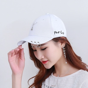 Dettaglio cappellino in cotone bianco con ricamo Paris, anelli in metallo e Torre Eiffel