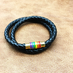 Close-up of black braided leather bracelet with golden magnetic clasp and rainbow stripes