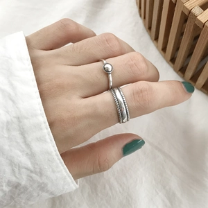 Detail of silver S925 minimalist geometric bead ring worn on hand in natural light