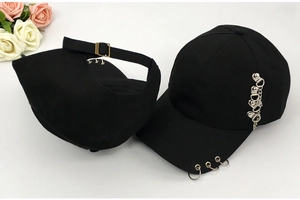 Detail of black cotton baseball cap featuring silver rings and side chain accessory